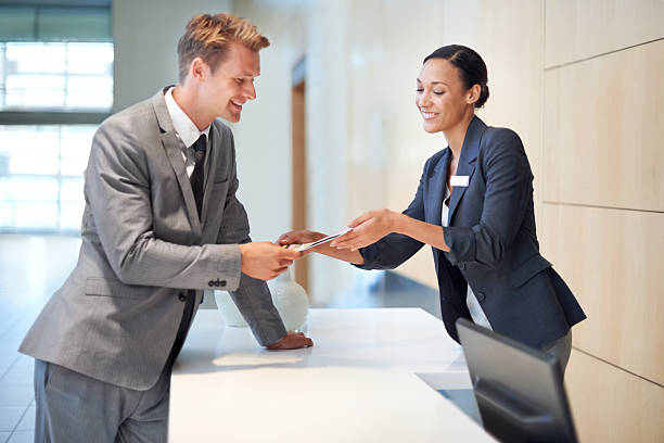 A handsome young man handing over a credit card to a woman